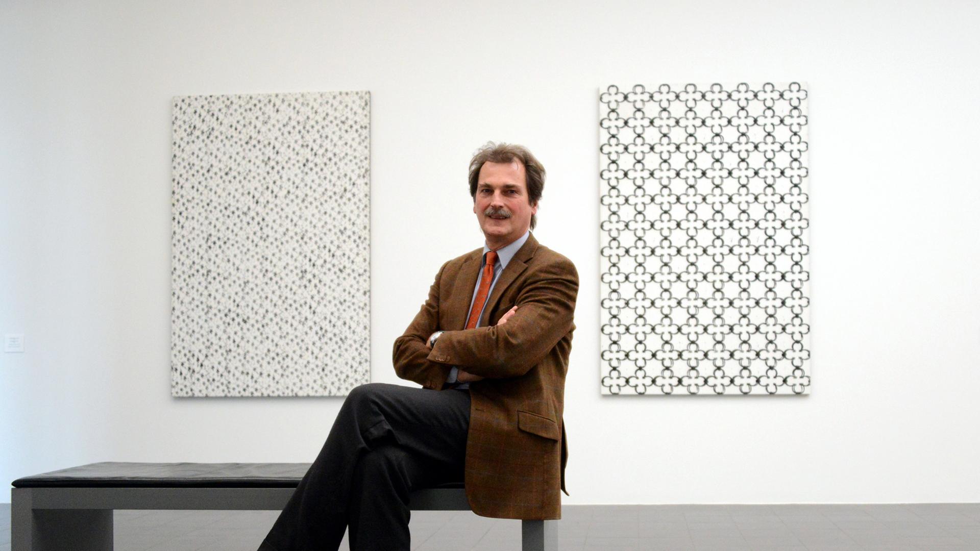 Der Direktor der Hamburger Kunsthalle, Hubertus Gaßner, sitzt am 06.12.2012 in der Kunsthalle in Hamburg. Im Hintergrund sind die Bilder "Untitled (P32)" (l) und "Untitled (P45)" von Christopher Wool zu sehen.