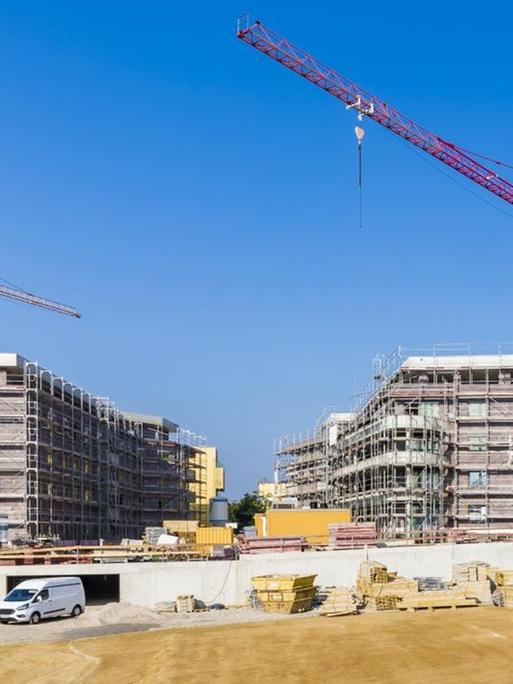 Panoramaaufnahme einer großen Baustelle mit vielen Kränen.