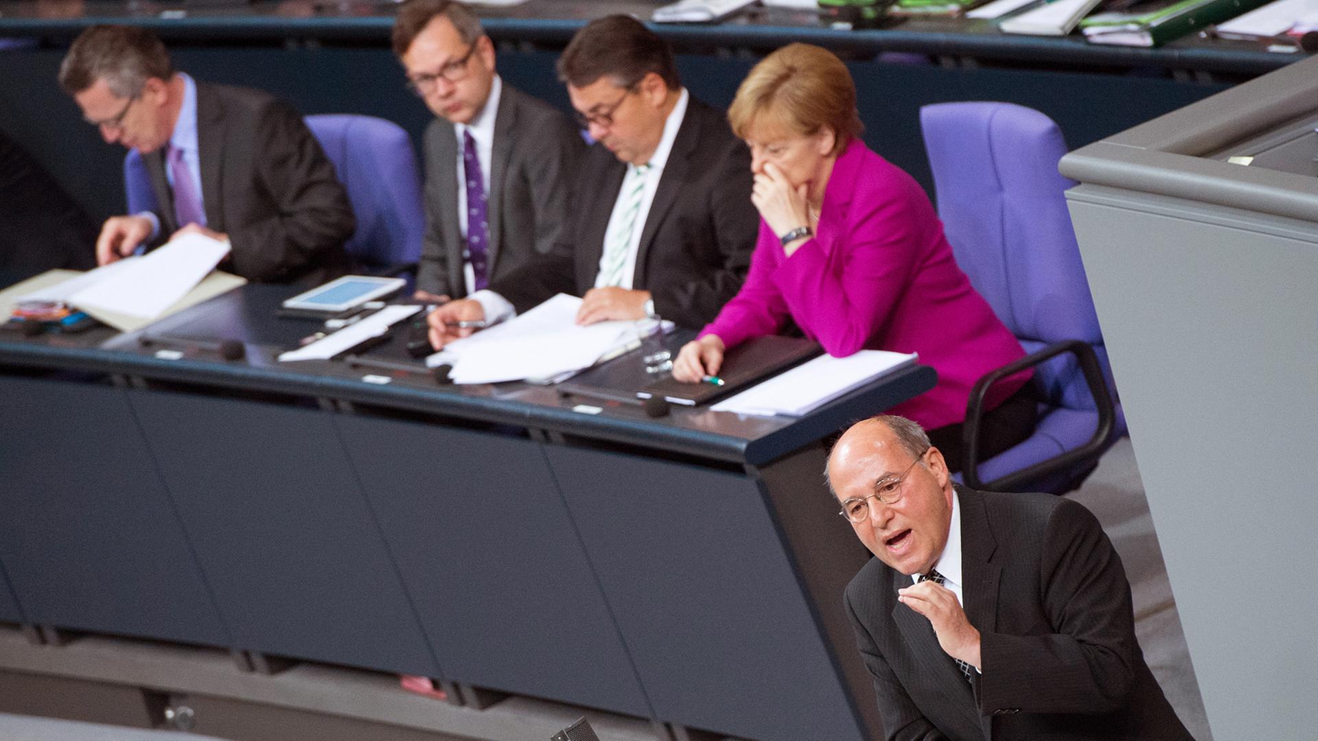 Der Fraktionsvorsitzende Gregor Gysi (Die Linke) spricht am 25.06.2014 im Bundestag in Berlin. Im Hintergrund sitzt Bundeskanzlerin Angela Merkel (CDU, r-l), Bundeswirtschaftsminister Sigmar Gabriel (SPD), Bundesentwicklungsminister Gerd Müller (CSU) und Bundesinnenminister Thomas de Maiziere (CDU). Der Bundestag debattiert über den Bundeshaushalt. F Der Fraktionsvorsitzende Gregor Gysi (Die Linke) spricht am 25.06.2014 im Bundestag in Berlin. Im Hintergrund sitzt Bundeskanzlerin Angela Merkel (CDU, r-l), Bundeswirtschaftsminister Sigmar Gabriel (SPD), Bundesentwicklungsminister Gerd Müller (CSU) und Bundesinnenminister Thomas de Maiziere (CDU). Der Bundestag debattiert über den Bundeshaushalt. F