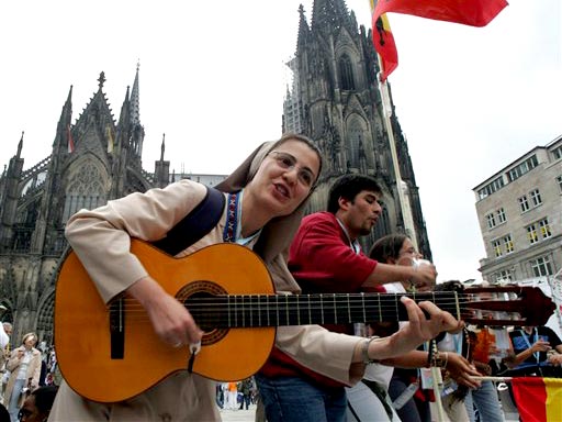 Eine Schwester aus Spanien gibt vor dem Dom in Köln ein Lied zum Besten.