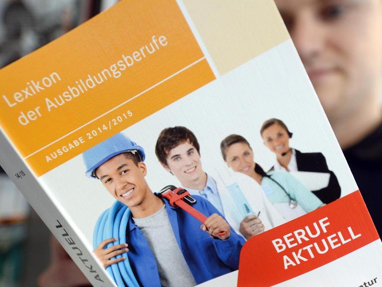 Ein Mann liest in der Agentur für Arbeit in Halle (Saale) (Sachsen-Anhalt) in einer Broschüre zur Berufsausbildung.