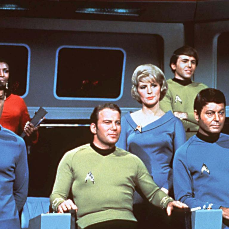 Die Crew des Raumschiffes USS Enterprise auf der Brücke in einer Szene der gleichnamigen Serie: (l-r) George Takei als Lieutenant Hikaru Sulu, Leonard Nimoy als Lieutenant Commander Spock vom Planeten Vulkan, Nichelle Nichols als Kommunikationsoffizier Lieutenant Uhura, William Shatner als Captain James Tiberius Kirk, Majel Barrett als Krankenschwester Christine Chapel, Walter Koenig als Sicherheitsoffizier Ensign Pavel Chekov, DeForest Kelley als Chefarzt Dr. Leonard Horatio McCoy, genannt "Pille" und James Doohan als Chef-Ingenieur Montgomery Scott , genannt "Scotty". (Aufnahme von 1967).