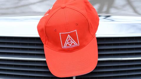 Rote Kappe mit IG Metall-Logo auf einem Auto. 