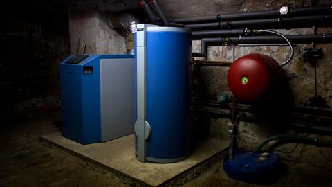 Ein Heizkessel einer etwa sechs Jahre alten Anlage und ein Warmwasserboiler stehen in einem Heizkeller.
