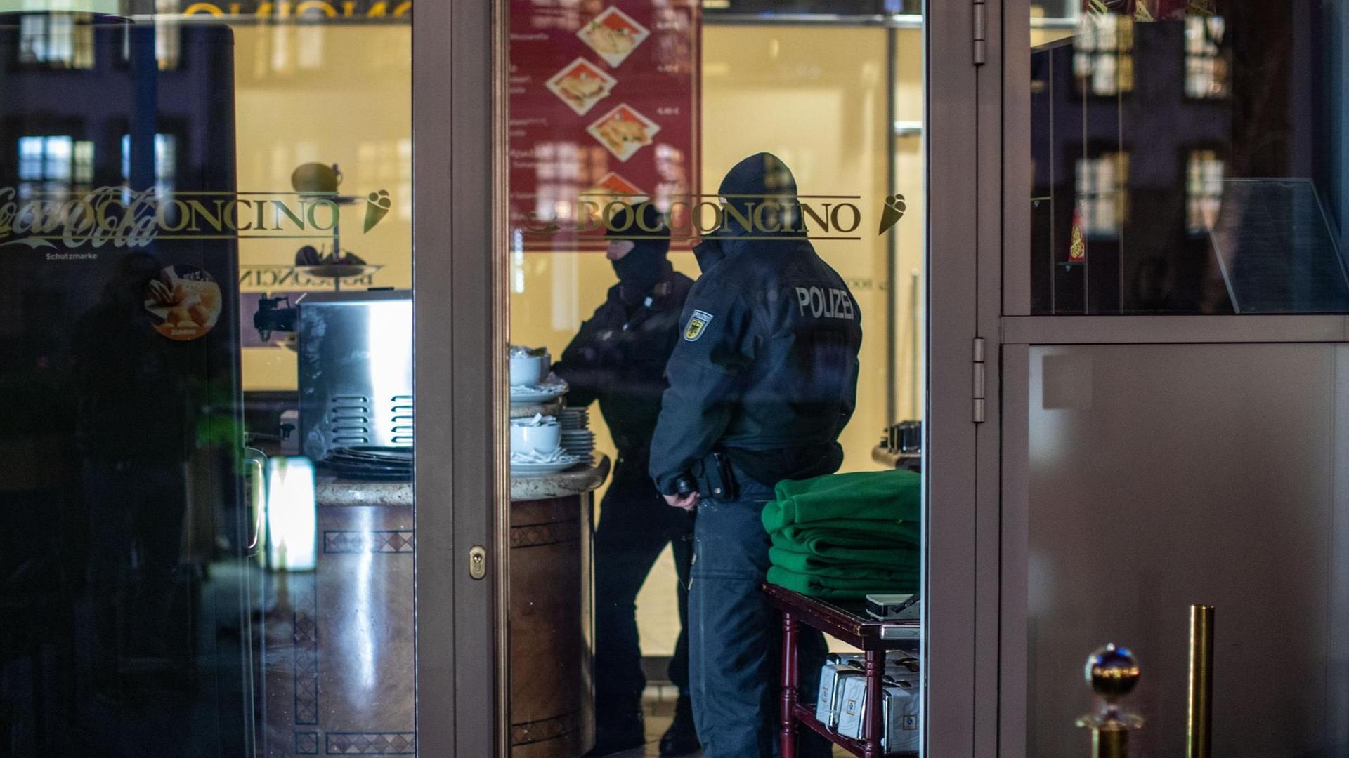 Polizisten stehen in einem Eis-Café 