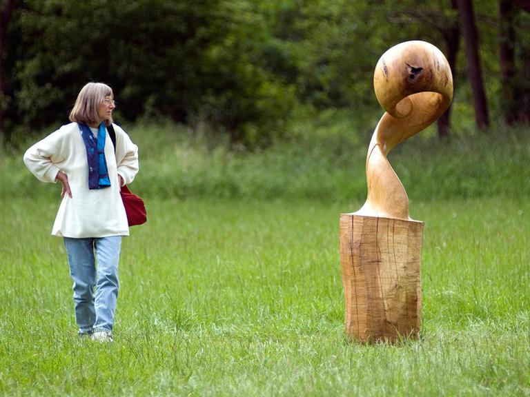 Eine Frau schaut sich im Wendland ein Kunstwerk im Rahmen der kulturellen Landpartie an.