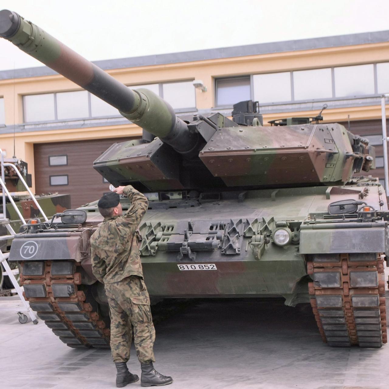 Ein Soldat begutachtet einen deutschen Leopard-Panzer.