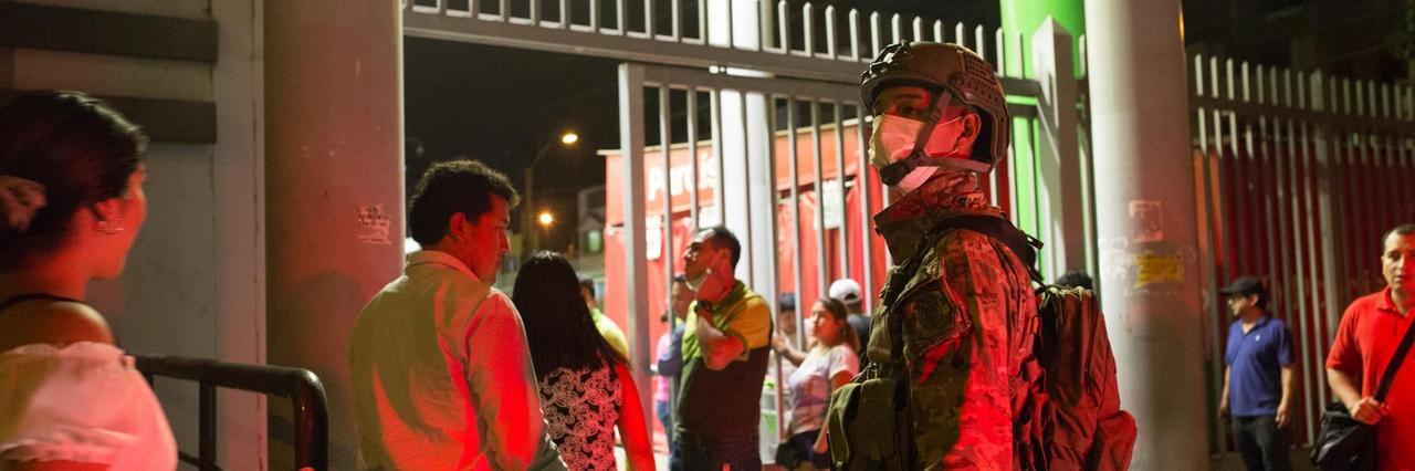 Ein Soldat mit Atemmaske beäugt in Lima Menschen, die einen Supermarkt betreten wollen. In Peru wurde wegen der Corona-Pandemie der Katastrophenfall ausgerufen.