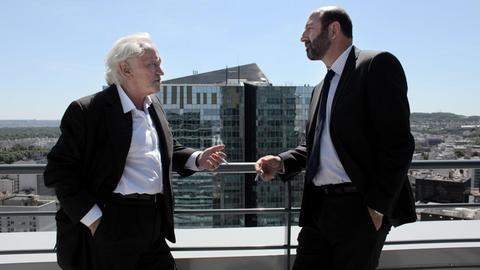 Szenenbild aus "Baron Noir": Kad Merad (Philippe Rickwaert) und Niels Arestrup (Präsident Laugier) rauchen gemeinsam eine Zigarette. Bild: Studiocanal / Jean-Claude Lother