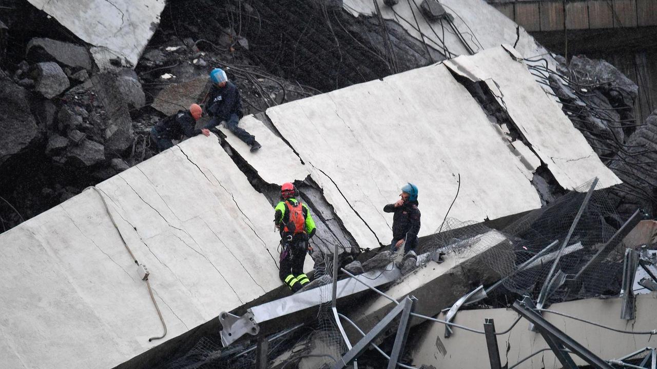 Rettungsarbeiten unter den Trümmern der eingestürzten Morandi Autobahnbrücke. 