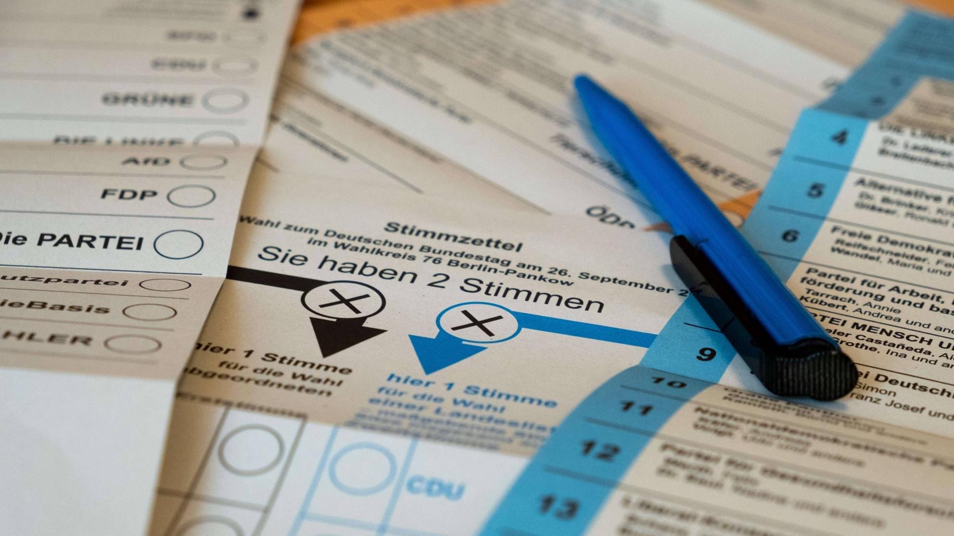 Ein Kugelschreiber liegt auf den Stimmzetteln für die bevorstehende Bundestagswahl und die Wahl zum Berliner Abgeordneten Haus.