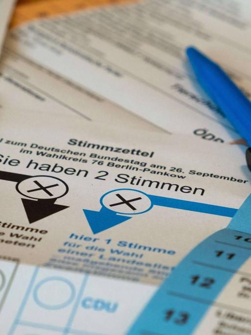 Ein Kugelschreiber liegt auf den Stimmzetteln für die bevorstehende Bundestagswahl und die Wahl zum Berliner Abgeordneten Haus.