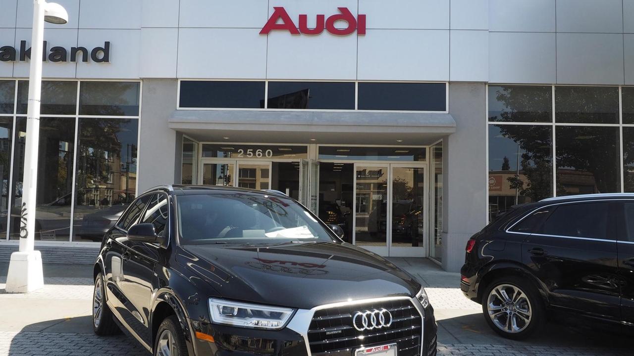 ein schwarzer Audi steht vor einem Autohaus