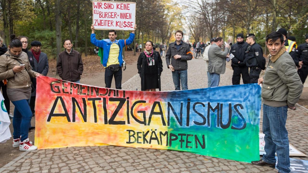 "Gemeinsam Antiziganismus bekämpfen" steht am 25.10.2013 vor dem Mahnmal für Sinti und Roma in Berlin bei einer Kundgebung auf einem Banner. Mit einer Demonstration unter dem Motto "Friedrich, es reicht! Schluss mit der rassistischen Hetze gegen Menschen aus Rumänien, Bulgarien und Asylsuchende!" protestierte eine Gruppe gegen die Politik der Bundesregierung. Foto: Florian Schuh/dpa ++