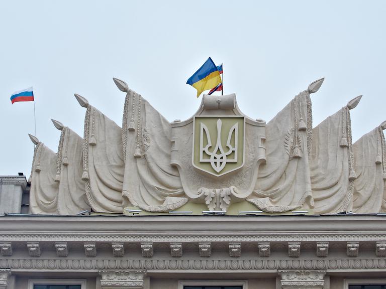 2.3.2014: Die ukrainische und die russische Fahne wehen auf dem Dach der Regionalregierung in Charkiw, Ostukraine, nachdem prorussische Demonstranten das Gebäude gestürmt haben.
