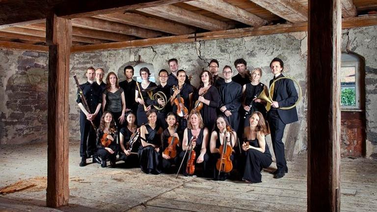 Die Musikerinnen und Musiker des Alte-Musik-Ensembles Compagnia di Punto stehen in einem historischen Raum 
