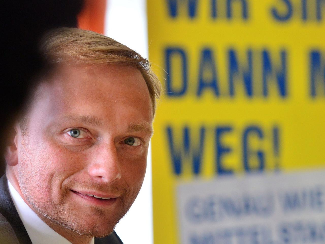 Der FDP-Bundesvorsitzende Christian Lindner sitzt am 06.08.2014 in Erfurt (Thüringen) bei einer Wahlkampfveranstaltung vor einem Wahlplakat der Thüringer FDP auf dem steht: "Wir sind dann mal weg. Genauso wie der Mittelstand"