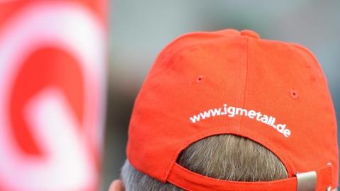 Ein Mann trägt am 10.01.2018 in Homburg (Saarland) bei einem Warnstreik am Werk der Firma Bosch eine Mütze mit der Aufschrift IG Metall. Mit Warnstreiks will die Gewerkschaft den Druck im Tarifstreit der Metall- und Elektroindustrie erhöhen. Foto: Oliver Dietze/dpa | Verwendung weltweit