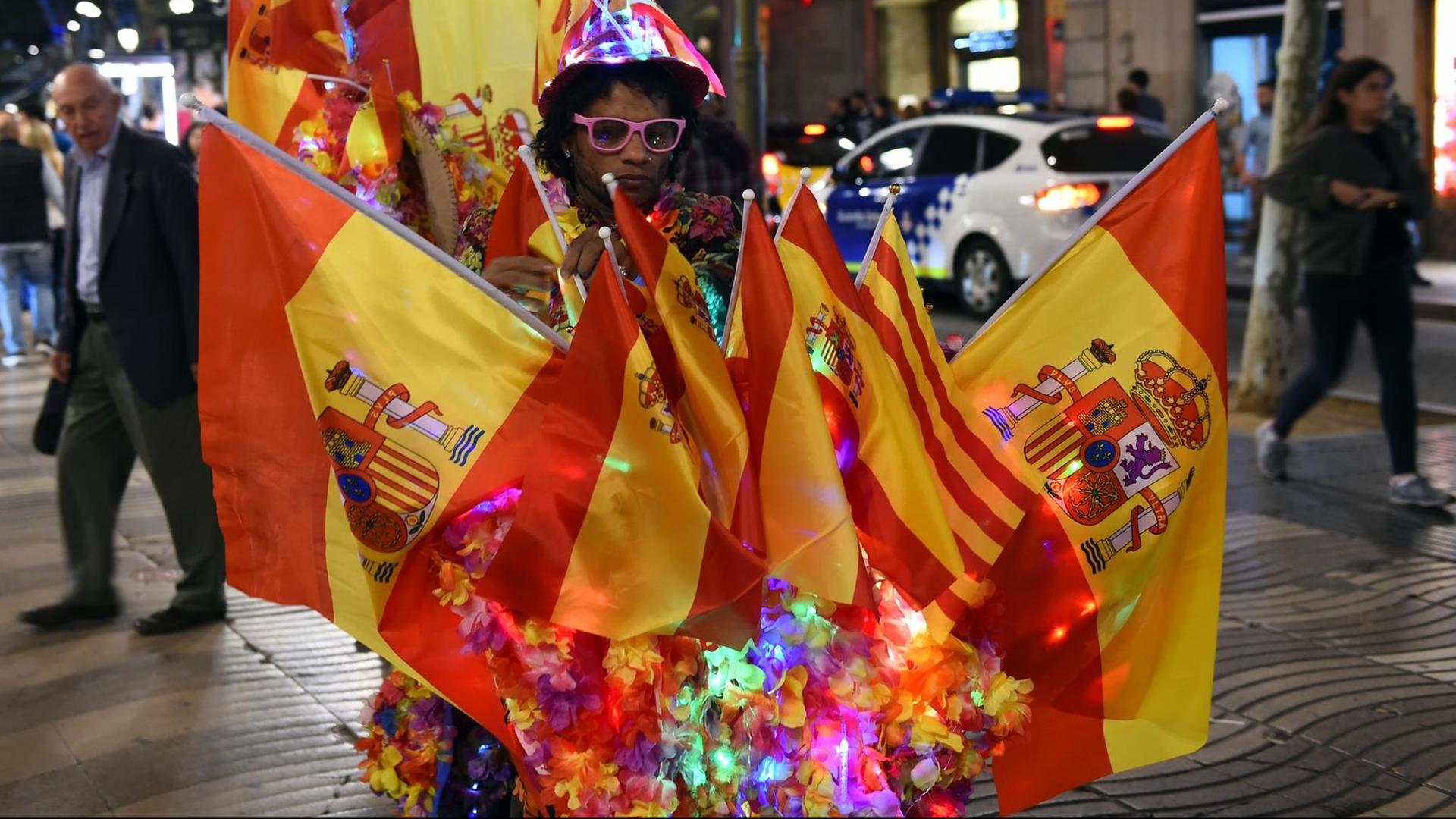 Der Lichtkünstler Jamal fährt am 29.10.2017 auf einem mit spanischen Fahnen geschmückten Fahrrad durch Barcelona.