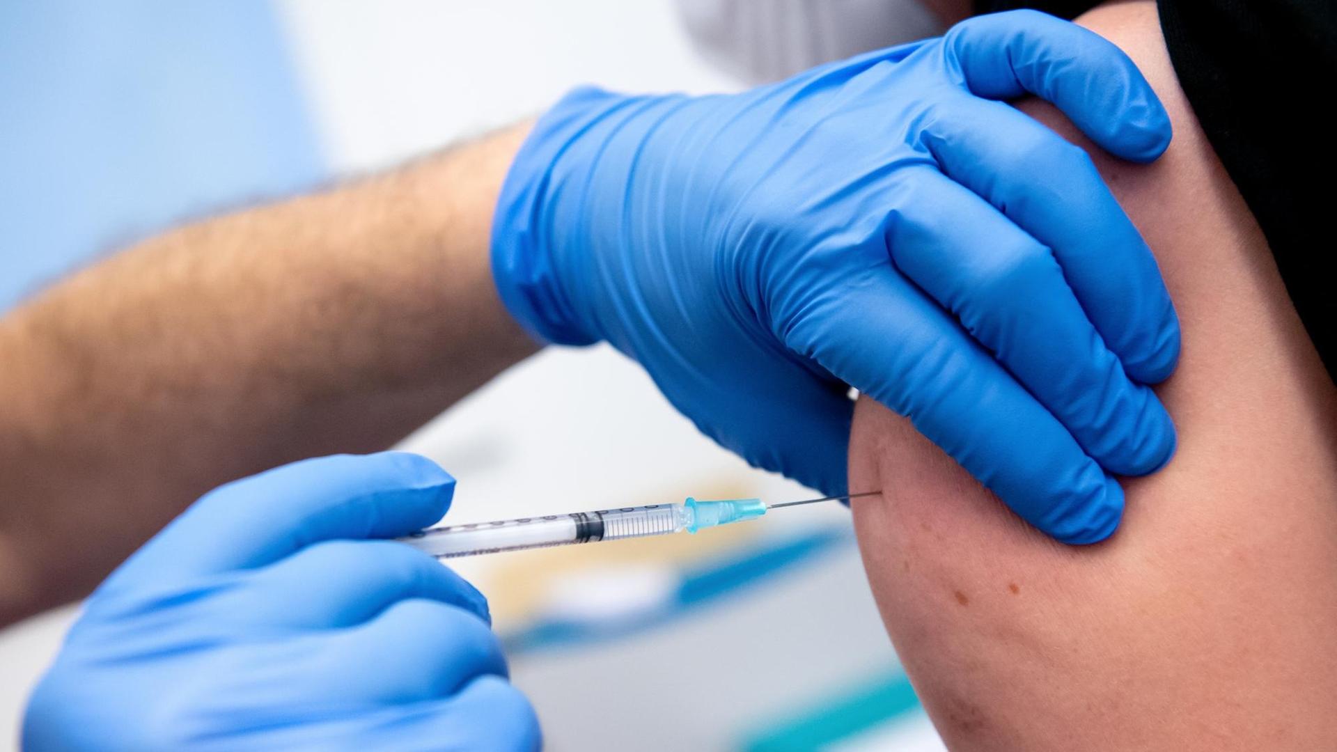Ein Mitarbeiter der Asklepios Klinik wird von einem Kollegen mit dem Corona-Impfstoff von Biontech/Pfizer geimpft. Zahlreiche Mitarbeiter der Klinik haben sich gegen das Coronavirus impfen lassen.