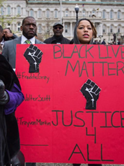 Demonstranten in Baltimore halten ein Schild hoch, auf dem steht: "Justice for all"