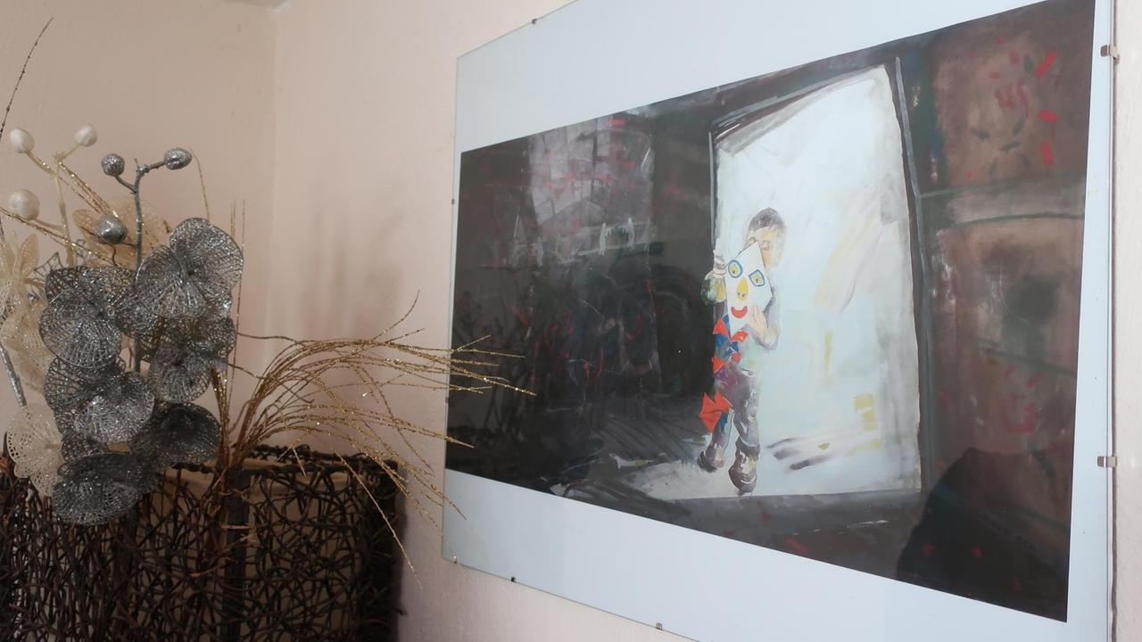 Ein Bild von einem Jungen mit Drachen hängt an einer Wohnzimmerwand