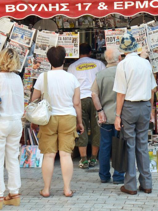 Nach der Einigung in Brüssel: Menschen in Athen lesen an einem Zeitungsstand; Aufnahme vom 13. Juli 2015