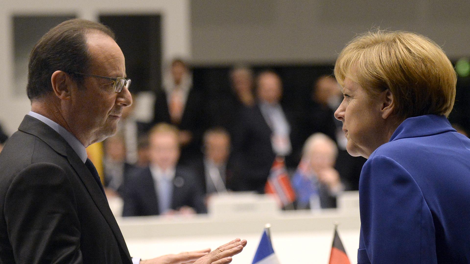 Frankreichs Präsident Francois Hollande und Bundeskanzlerin Angela Merkel unterhalten sich bei der Europa-Asien-Konferenz in Mailand.