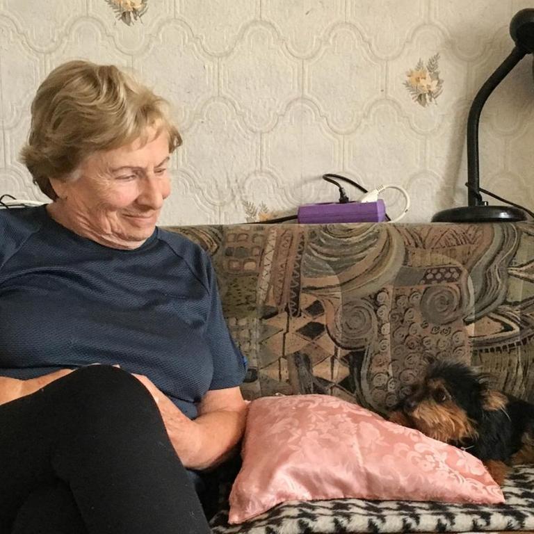 Paulina Zerluk sitzt zu Hause in Koblenz auf ihrem Sofa, neben ihr Hund Knopka