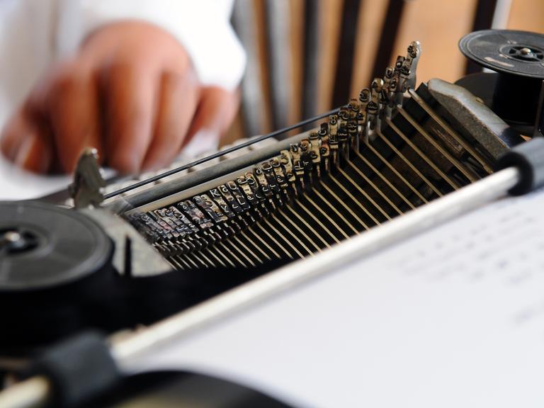 In einer alten mechanischen Schreibmaschine steckt ein Blatt Papier.