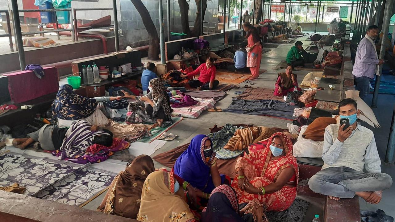 Patienten liegen und sitzen auf Decken auf dem Boden im RML Hospital in Neu-Delhi in Indien, aufgenommen am 7. November 2020.