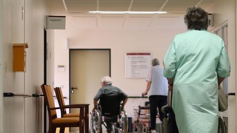 Heike Jakobi vom ehrenamtlichen Kranken-Lotsendienst schiebt einen Patienten zur Therapie im Albertinen-Haus in Hamburg.