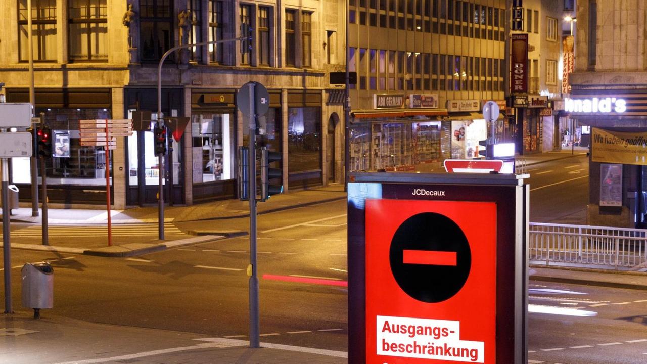 Eine Digitalanzeige in der Kölner Innenstadt weist auf die geltenden r Ausgangsbeschränkungen in der Zeit von 21 Uhr bis 5 Uhr hin