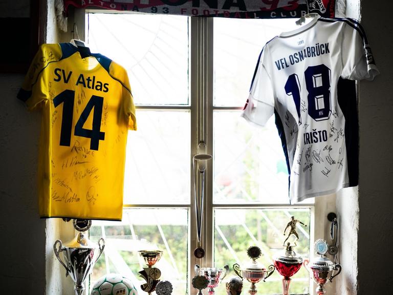 Ein Fußballfan hat all seine Pokale und Trikots vom SV Atlas Delmenhorst und vom VfL Osnabrueck im Fenster drapiert.