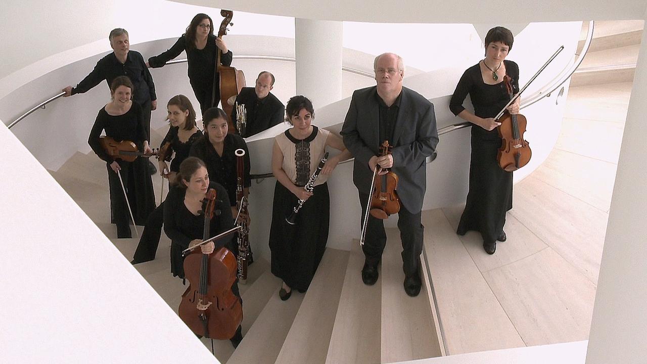 Die Musikerinnen und Musiker des Ensembles Horizonte stehen mit ihren Instrumenten in einem Treppenhaus 