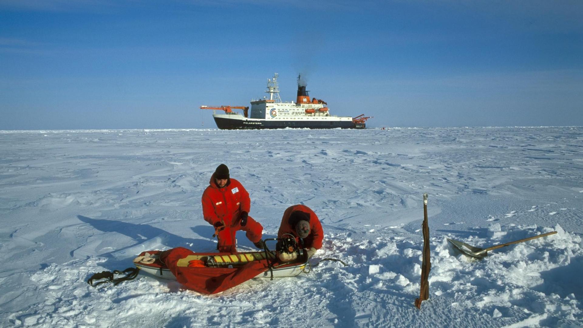 Polarforscher in der Arktis . Im Hintergrund das deutsche Forschungsschiff Polarstern des Alfred-Wegener-Instituts (AWI) für Meeres- und Polarforschung. (Undatierte Aufnahme