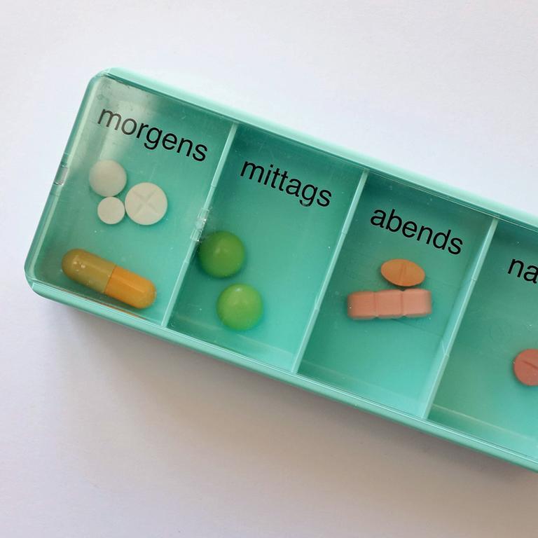 Tabletten in einer Plastikbox mit vier Fächern