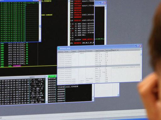 Ein Mann sitzt vor einem Computerbildschirm mit verschiedenen geöffneten Fenstern. Ein Mann sitzt vor einem Computerbildschirm mit verschiedenen geöffneten Fenstern.