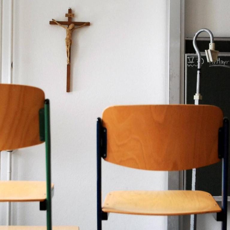 Hochgestellte Stühle in einem Klassenzimmer im Canisius-Kolleg - im Hintergrund an der Wand ein Kruzifix. Hochgestellte Stühle in einem Klassenzimmer im Canisius-Kolleg - im Hintergrund an der Wand ein Kruzifix.