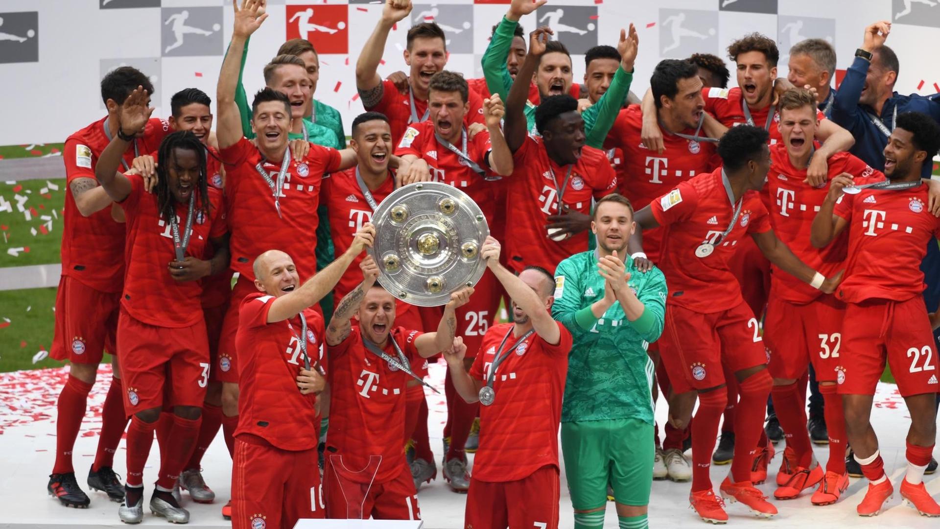 Spieler von München jubeln mit der Meisterschale bei der Siegerehrung für die Meisterschaft.
