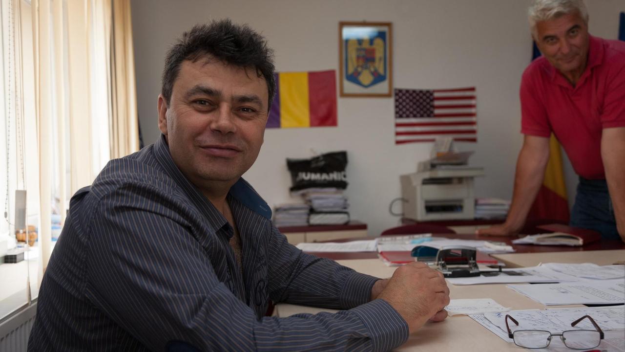 Der Bürgermeister von Deveselu, Ion Aliman. In seinem Arbeitszimmer im Rathaus hat er neben der rumänischen Flagge jetzt auch die US-amerikanische hängen. 