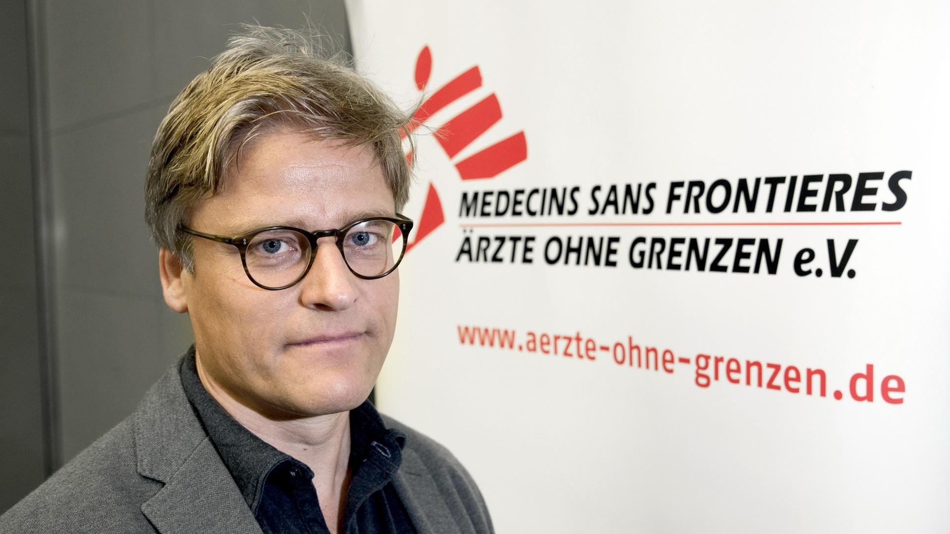Tankred Stöbe, Vorstandschef von Ärzte ohne Grenzen, vor dem Logo der Organisation