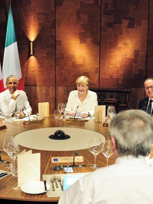 EU-Ratspräsident Donald Tusk (vorne links) und EU-Kommissionspräsident Jean-Claude Juncker sitzen mit den G7-Staats- und Regierungschefs am Tisch.