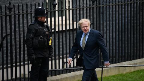 Premierminister Boris Johnson läuft vor Downing Street 10 an einem Wachpolizisten vorbei.