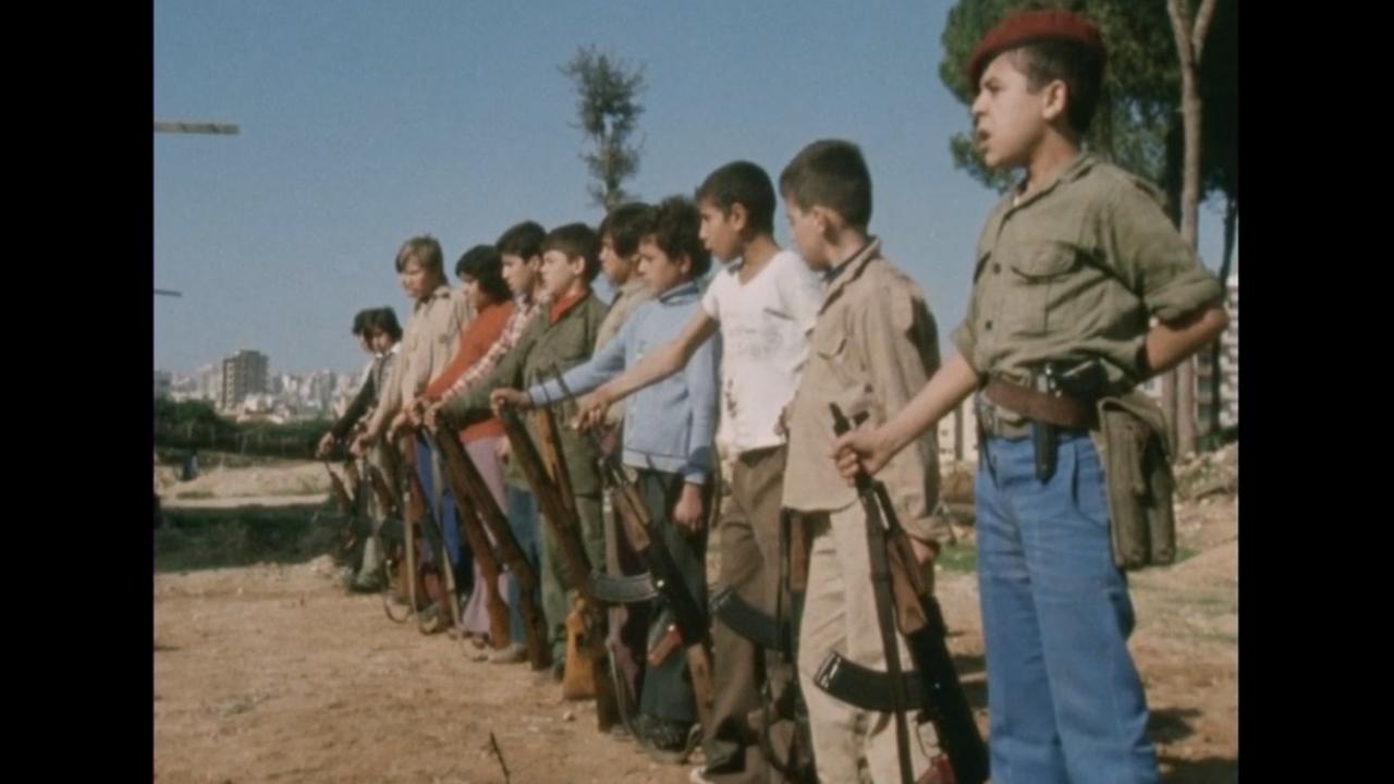 Kinder mit Maschinengewehren stehen in einer Reihe.
