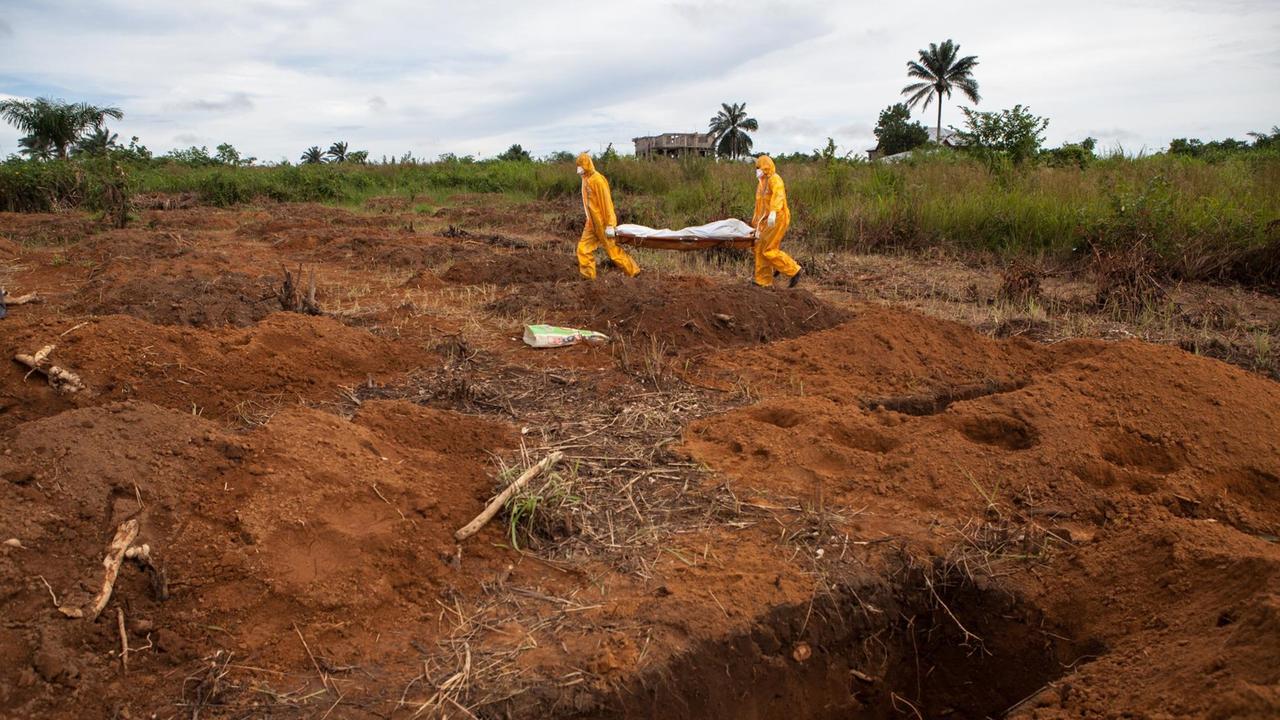 Freiwillige in Schutzanzügen begraben einen Ebola-Toten in Waterloo, 30 Kilometer südostlich von Feetown / Sierra Leone