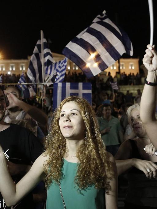ureJunge Griechinnen feiern in Athen mit Flaggen des Landes in der Hand.