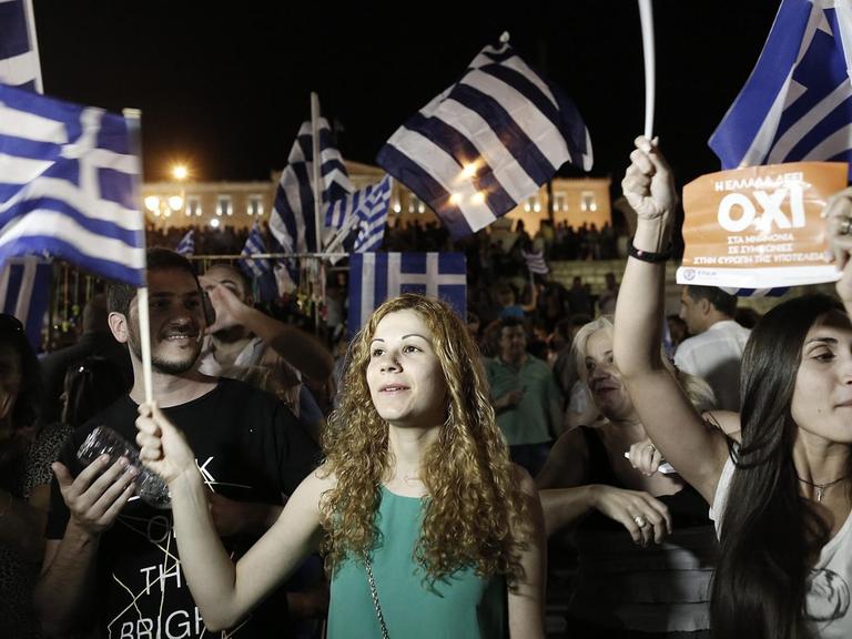 ureJunge Griechinnen feiern in Athen mit Flaggen des Landes in der Hand.