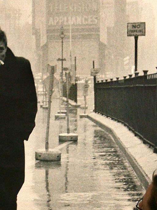 Eine Frau blickt auf ein Schwarz-Weiß-Bild mit James Dean, der den Times Square entlang geht.