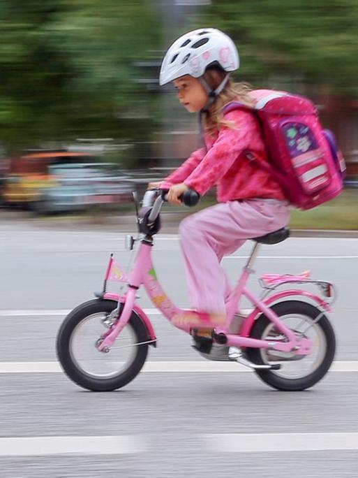 Das Bild zeigt ein kleines Mädchen auf einem Fahrrad im Hamburger Straßenverkehr